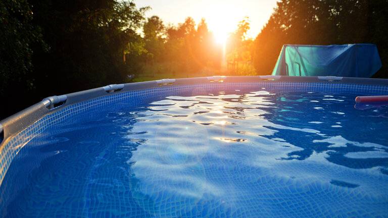Schwimmbad mit Metallrahmen für Haus und Garten. Rahmen Schwimmbad im Hof. Garten im Hintergrund. Sommerurlaub Spaß und Erholung.