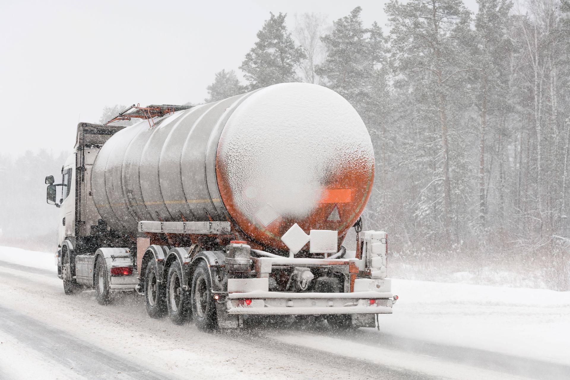Heizoel-LKW faehrt durch winterliches Muenchen bei Schneefall – Symbol fuer Versorgungssicherheit trotz schwieriger Bedingungen