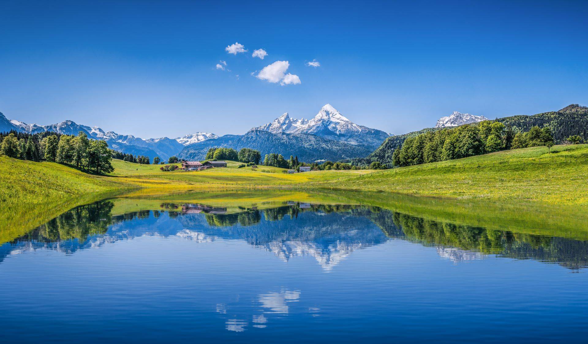 Ruhiger See in Bayern mit Watzmann und grüner Wiese im Vordergrund