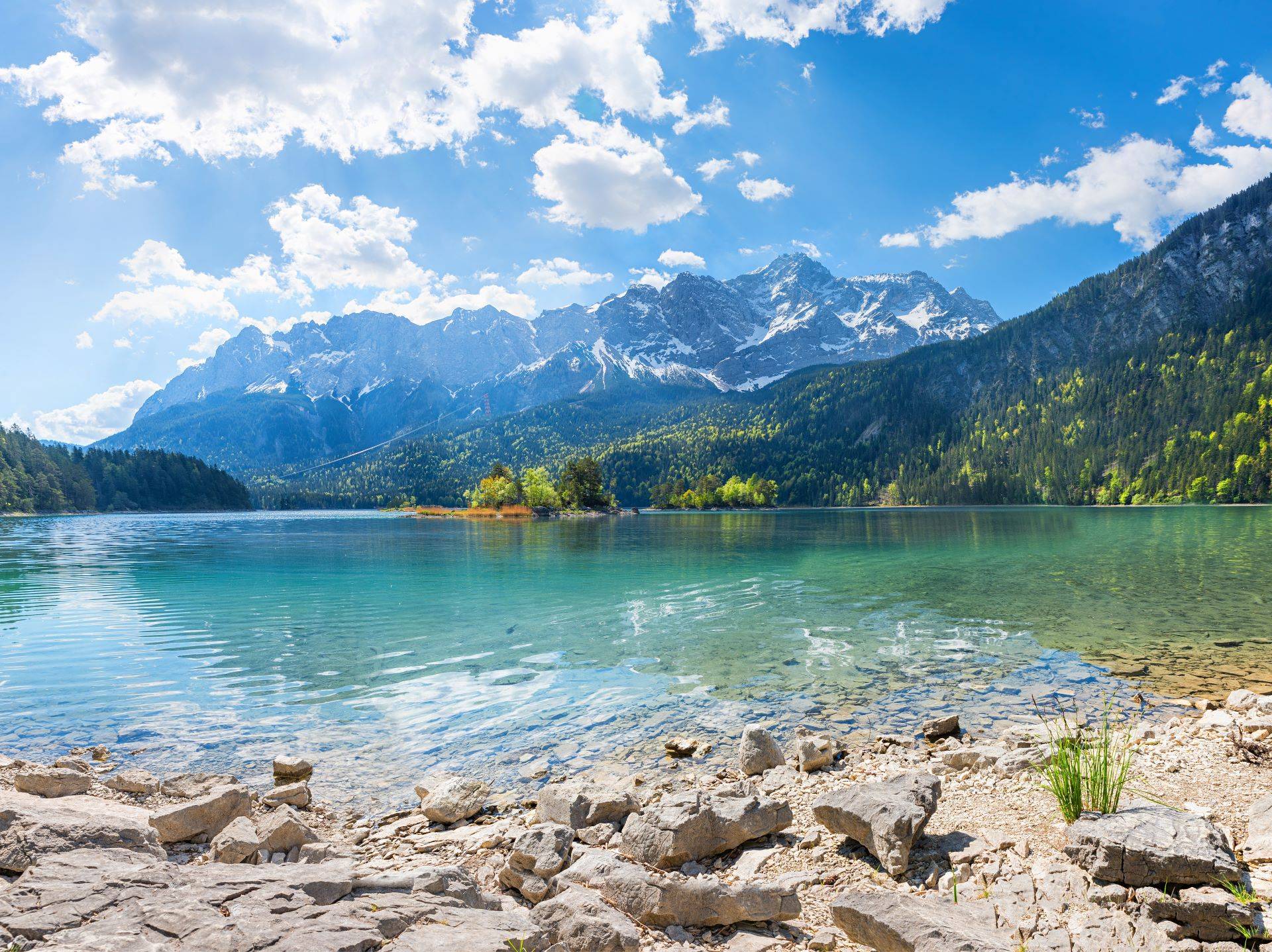 Klarer Bergsee mit Alpenpanorama in Bayern bei Sonnenschein